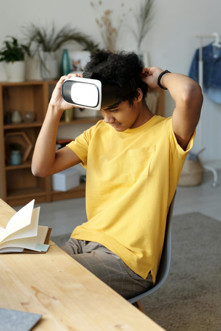 Teen boy in yellow shirt using VR headset at home, enjoying virtual reality.
